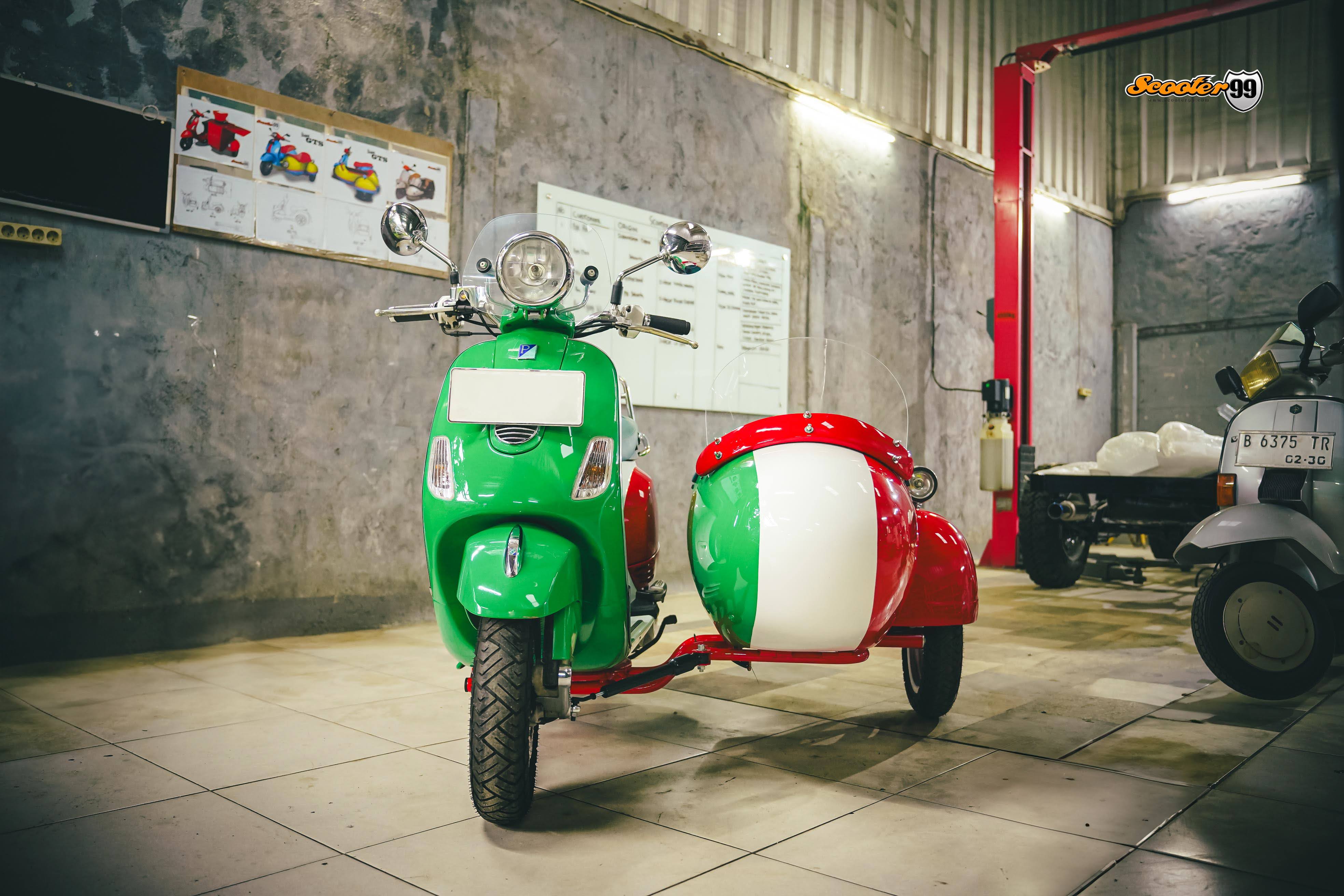 Scooter99 workshop team matching the paint color of a custom Vespa Italian sidecar.